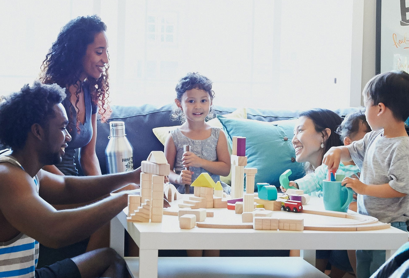 A family at a living room table playing with blocks and colors