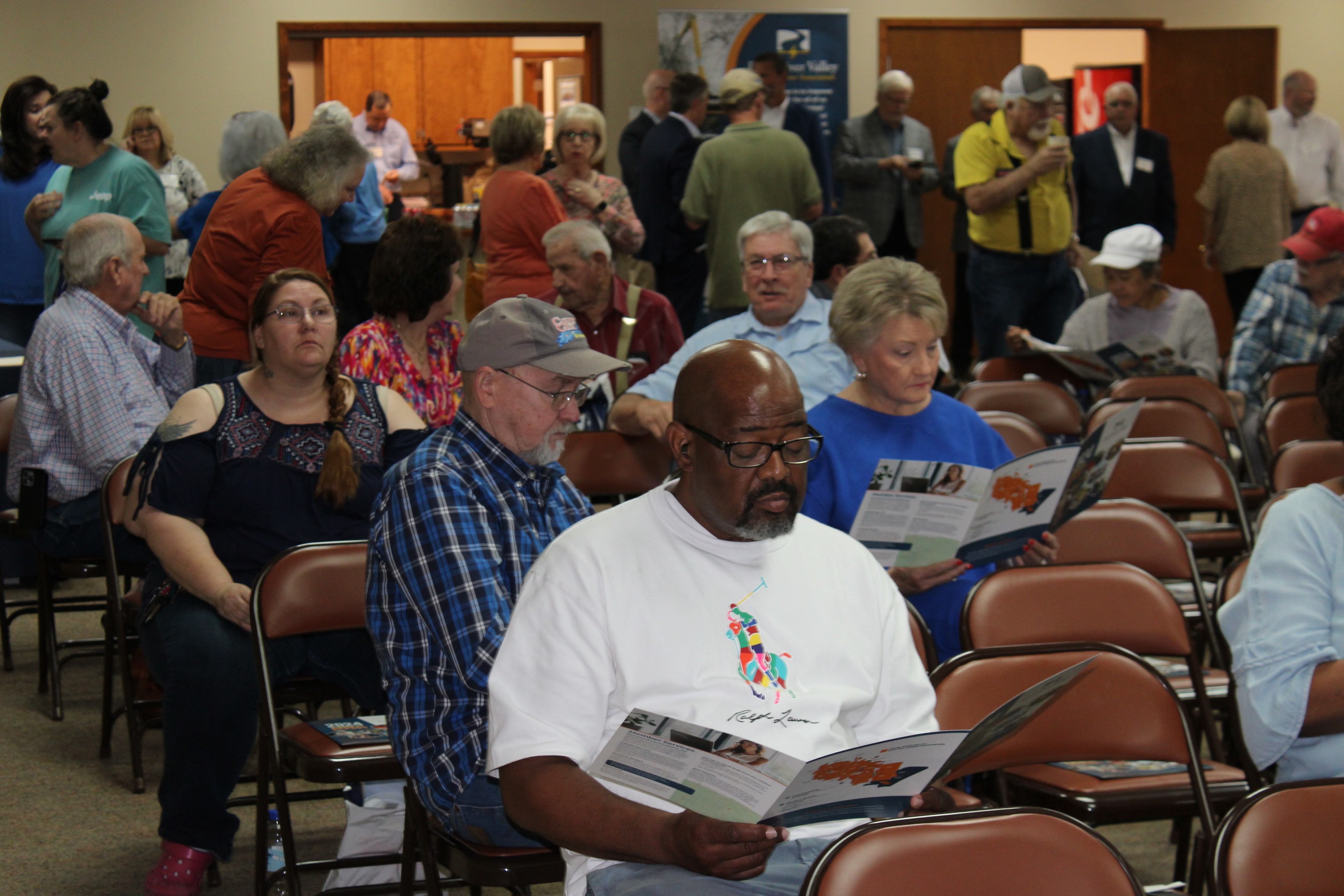 Picture of a community in a hearing or seminar learning more about Pearl River Valley as they are reading pamphlets and looking towards a speaker